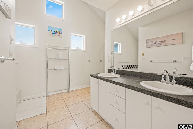 full bathroom with baseboards, tile patterned floors, a sink, and double vanity