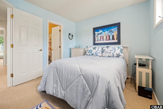 bedroom featuring light carpet and a textured ceiling