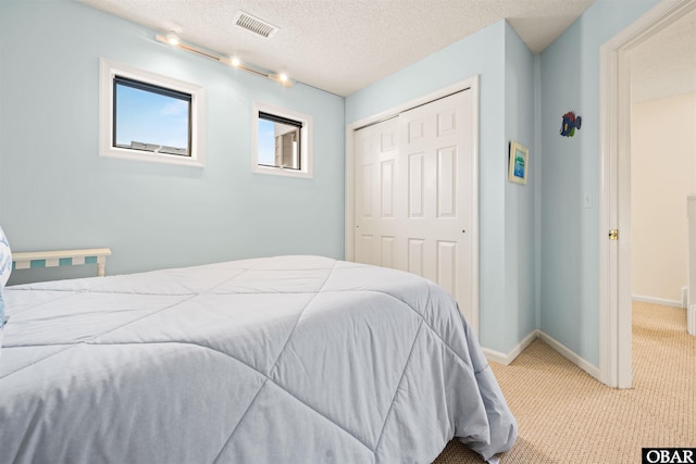 bedroom with baseboards, carpet flooring, visible vents, and a closet