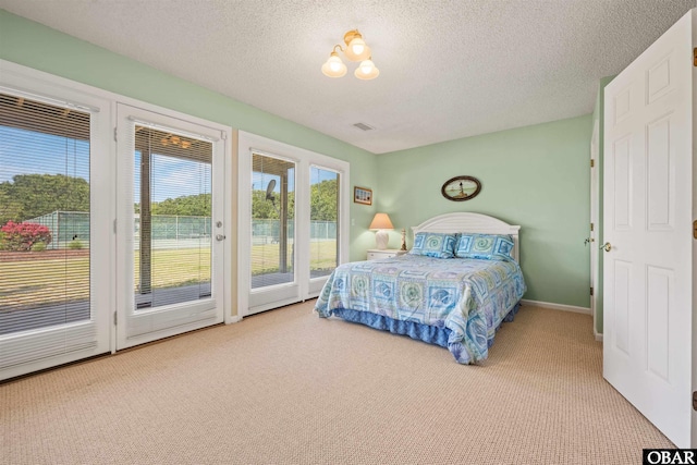 bedroom featuring a textured ceiling, carpet, access to exterior, and visible vents