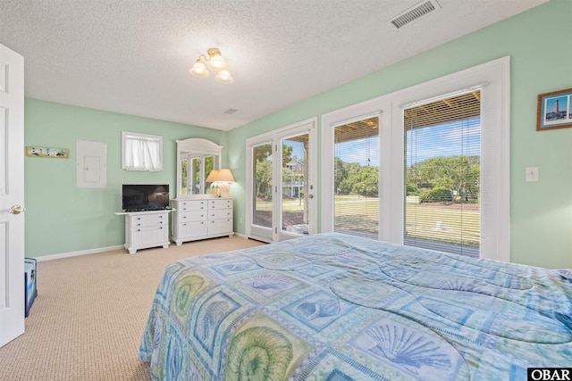 bedroom featuring a textured ceiling, access to outside, visible vents, and light colored carpet