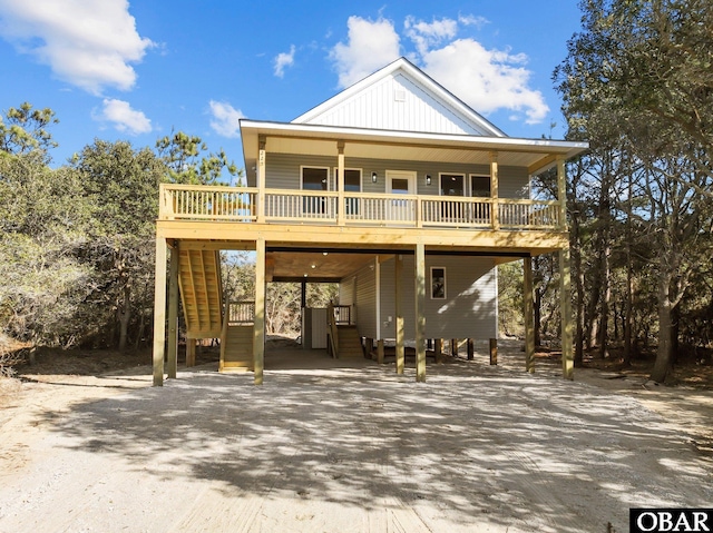 view of front of house featuring a carport, driveway, stairs, and board and batten siding