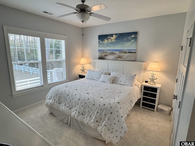 bedroom with baseboards, visible vents, light colored carpet, and ceiling fan