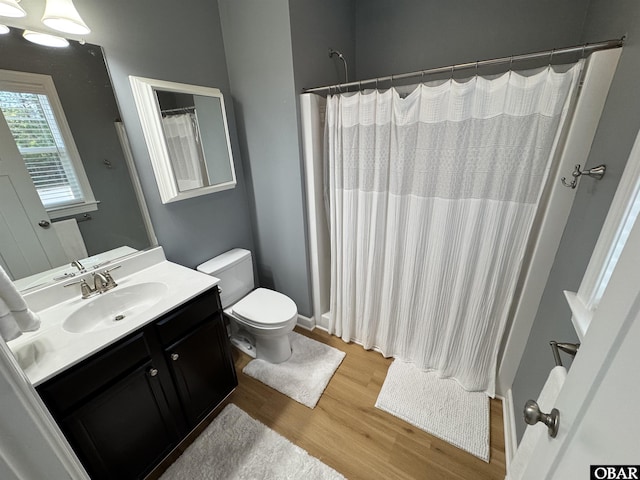 full bathroom featuring a shower with curtain, vanity, toilet, and wood finished floors