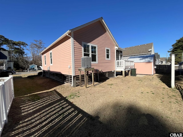 rear view of house with fence and a deck