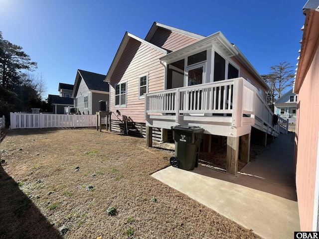 rear view of house featuring fence, a patio area, and a deck