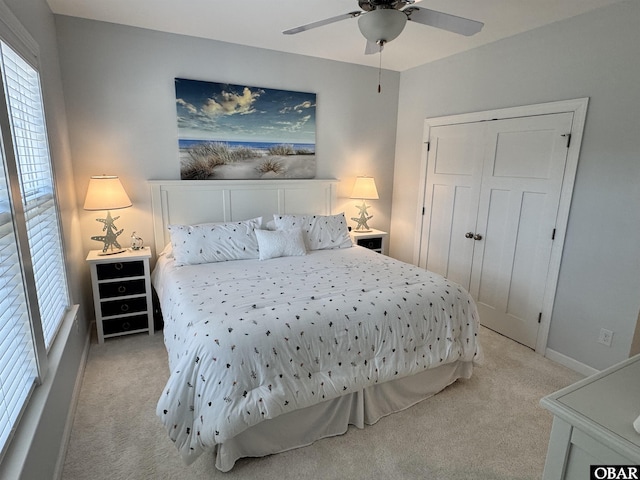 bedroom featuring a ceiling fan, a closet, and light carpet