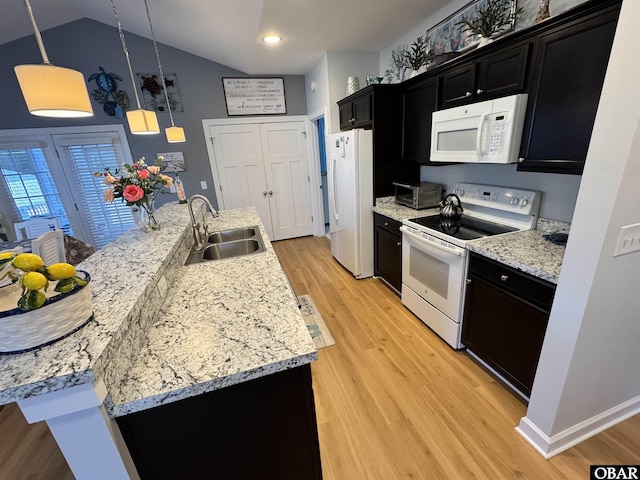 kitchen featuring decorative light fixtures, lofted ceiling, light wood-style flooring, a sink, and white appliances