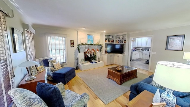 living room with built in shelves, light wood-type flooring, and crown molding