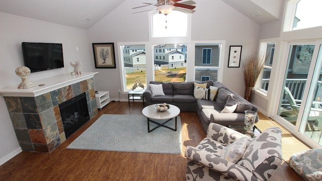 living area featuring dark wood-style floors, a fireplace, a ceiling fan, high vaulted ceiling, and baseboards