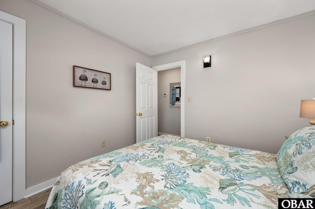 bedroom with wood finished floors and baseboards