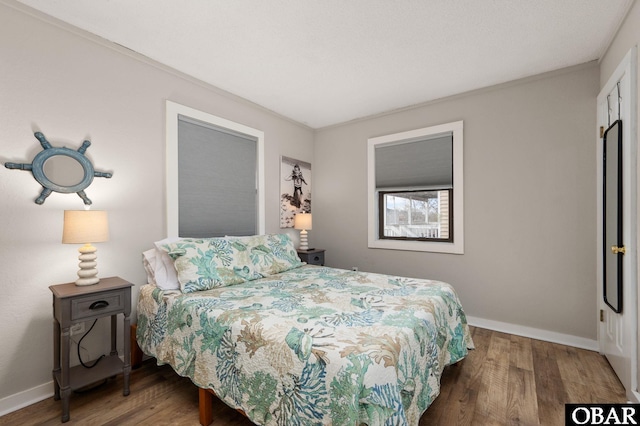 bedroom with dark wood-style flooring and baseboards