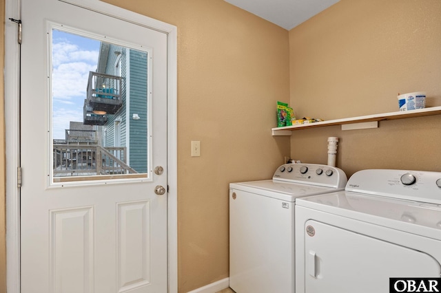 washroom with laundry area, washing machine and dryer, and baseboards