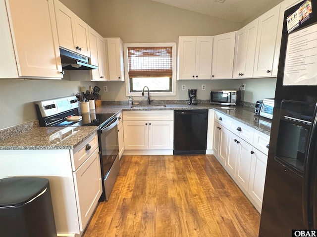 kitchen with under cabinet range hood, a sink, white cabinets, black appliances, and dark stone countertops