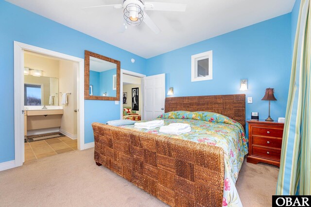 carpeted bedroom with a ceiling fan, baseboards, and ensuite bathroom