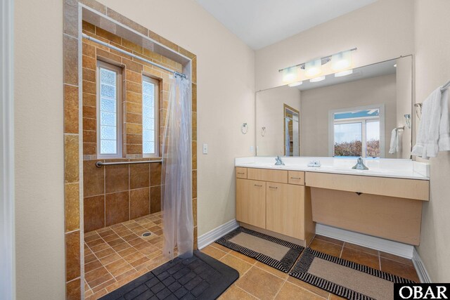 bathroom featuring a tile shower, a wealth of natural light, and vanity