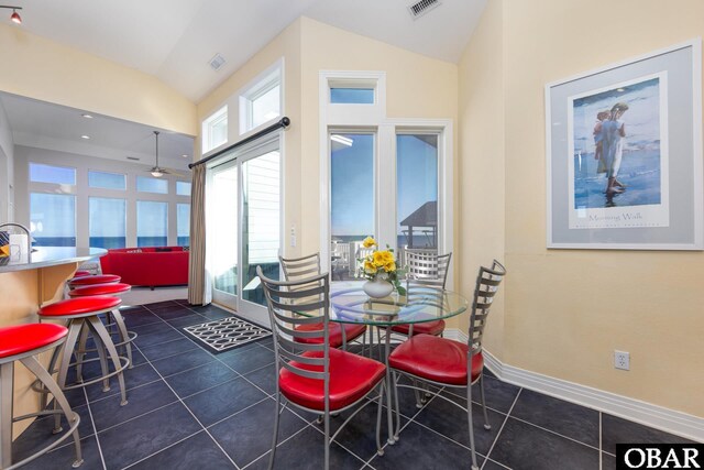 dining space featuring visible vents, baseboards, ceiling fan, vaulted ceiling, and dark tile patterned floors