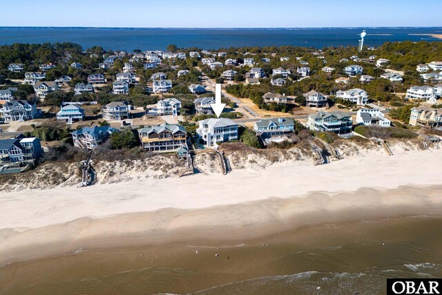 birds eye view of property featuring a beach view, a water view, and a residential view