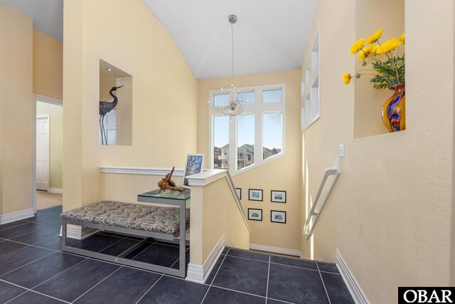 stairs with baseboards, high vaulted ceiling, a notable chandelier, and tile patterned floors