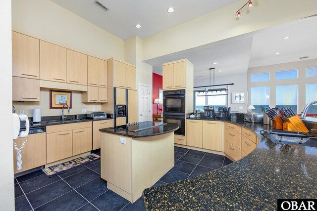 kitchen with dark tile patterned flooring, a sink, visible vents, black appliances, and light brown cabinetry