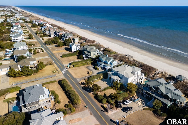 drone / aerial view featuring a view of the beach, a water view, and a residential view