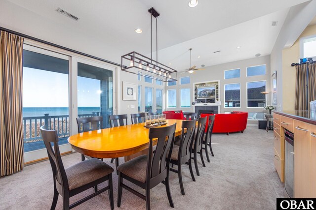 dining space featuring recessed lighting, light carpet, a water view, a ceiling fan, and visible vents