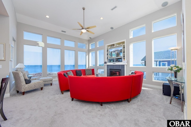 carpeted living area featuring baseboards, a fireplace, visible vents, and recessed lighting