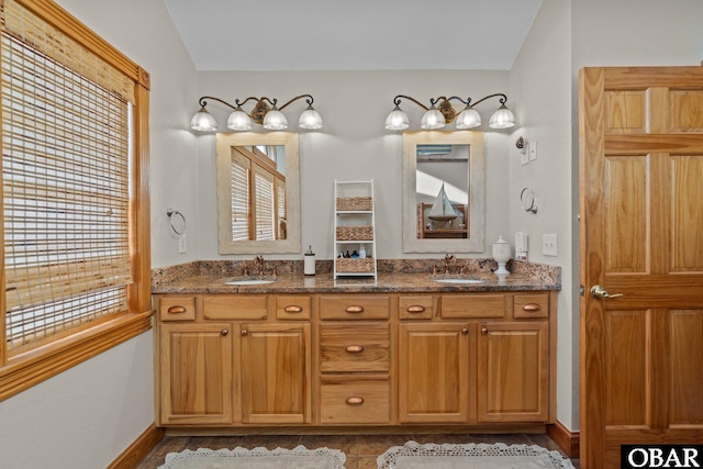 bathroom featuring double vanity, plenty of natural light, and a sink