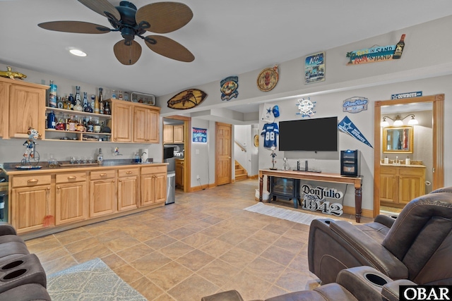 living area with bar, stairs, baseboards, and a ceiling fan