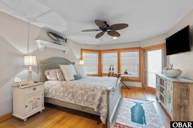 bedroom with baseboards, multiple windows, and light wood finished floors