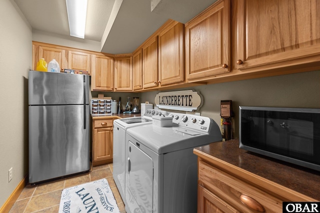 clothes washing area featuring laundry area, baseboards, washer and dryer, and light tile patterned flooring