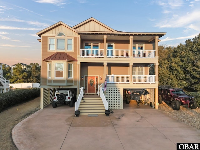 view of front of property featuring a carport, a porch, a balcony, and board and batten siding