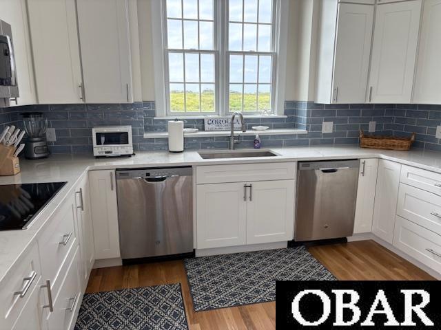 273 Whites Pt Lot 183, Corolla, NC 27927 - kitchen with appliances with stainless steel finishes, wood finished floors, white cabinetry, and light countertops