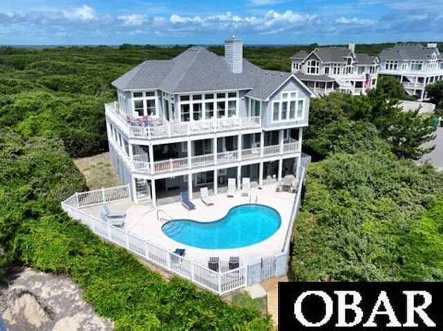 273 Whites Pt Lot 183, Corolla, NC 27927 - back of house with a patio, a balcony, an outdoor pool, and a chimney