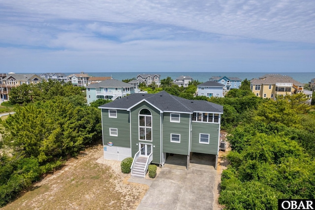 1045 Whalehead Dr Lot 27, Corolla, NC 27927 - view of front of home with a shingled roof, a water view, driveway, and stairway