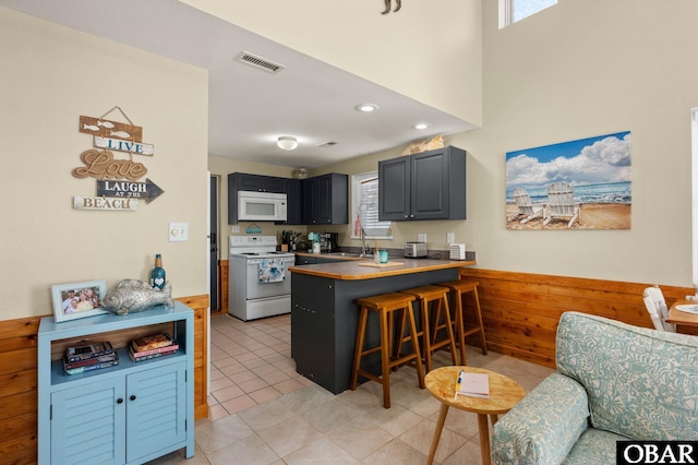 300 S Virginia Dare Trl Lot 1, Kill Devil Hills, NC 27948 - kitchen featuring white appliances, healthy amount of natural light, a peninsula, a breakfast bar, and recessed lighting