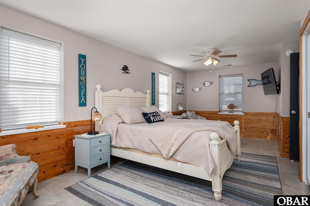 300 S Virginia Dare Trl Lot 1, Kill Devil Hills, NC 27948 - bedroom featuring light tile patterned floors, a wainscoted wall, a ceiling fan, and wooden walls