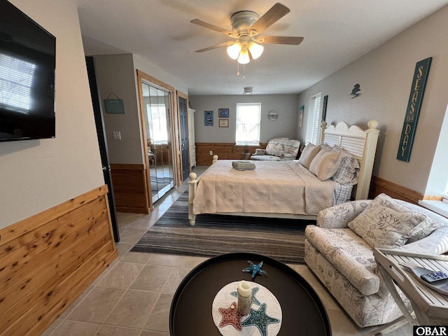 300 S Virginia Dare Trl Lot 1, Kill Devil Hills, NC 27948 - bedroom featuring wainscoting, light tile patterned flooring, a ceiling fan, and wood walls
