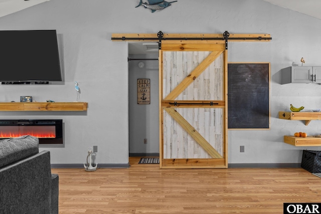 103 Nathan Dr Lot # 2, Grandy, NC 27939 - living area featuring lofted ceiling, wood finished floors, a barn door, and a glass covered fireplace