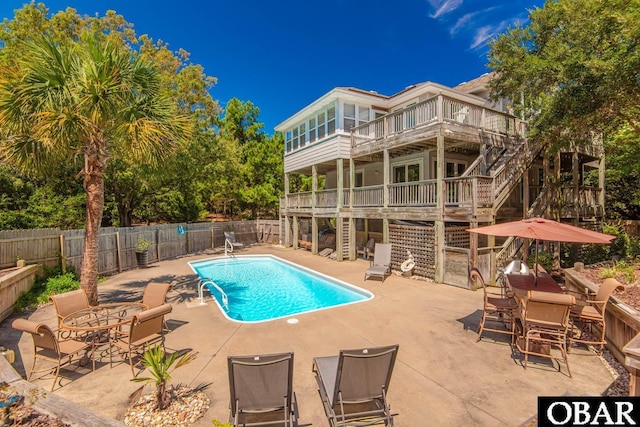 view of swimming pool with a fenced in pool, fence, stairs, a deck, and a patio area