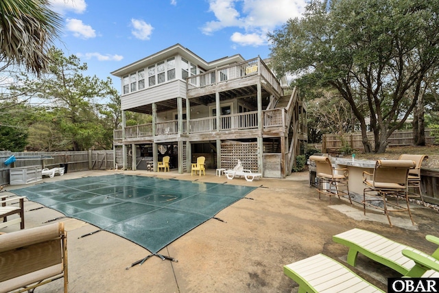 view of swimming pool with a wooden deck, a fenced backyard, stairs, and a patio area