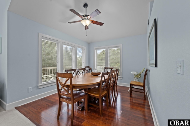 dining area featuring dark wood-type flooring, a ceiling fan, and baseboards