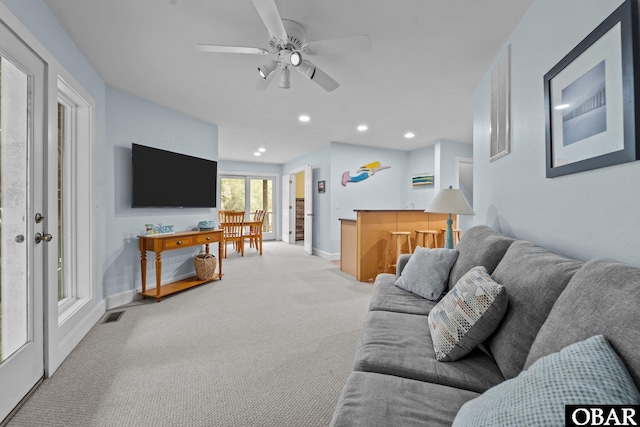 living room with visible vents, baseboards, light colored carpet, recessed lighting, and a ceiling fan