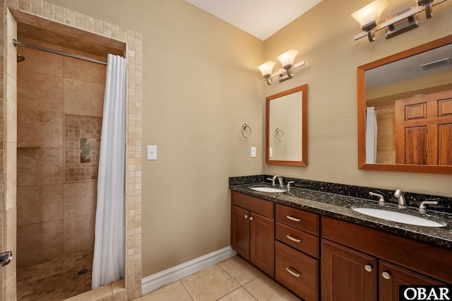 bathroom with tile patterned flooring, a stall shower, double vanity, and baseboards