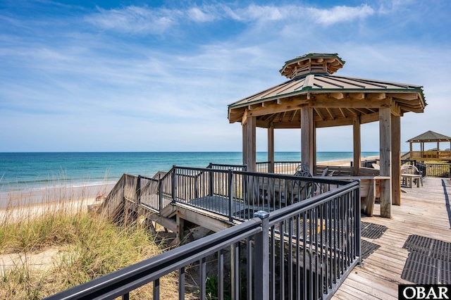 wooden deck with a gazebo and view of water and beach