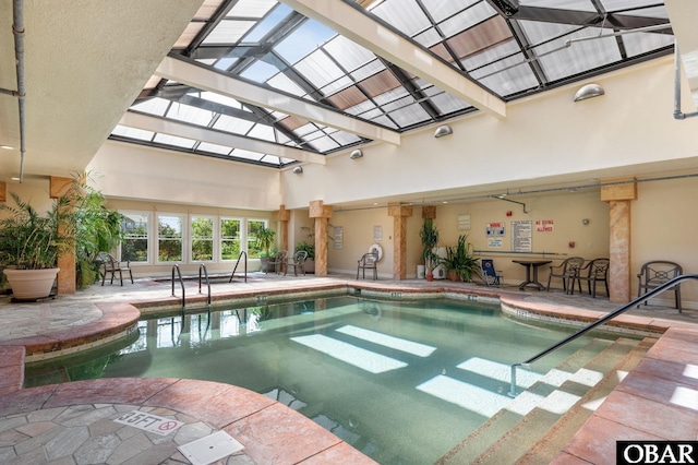 indoor pool featuring a patio and glass enclosure