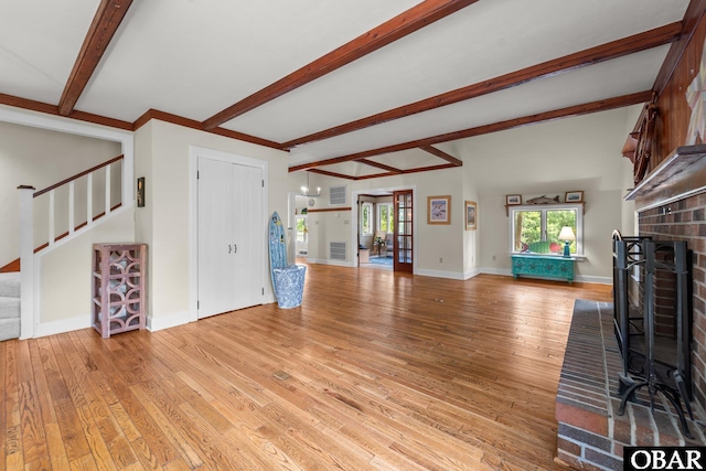 56 Ginguite Trl Lot 9, Southern Shores, NC 27949 - unfurnished living room featuring beamed ceiling, stairway, light wood finished floors, a fireplace, and baseboards