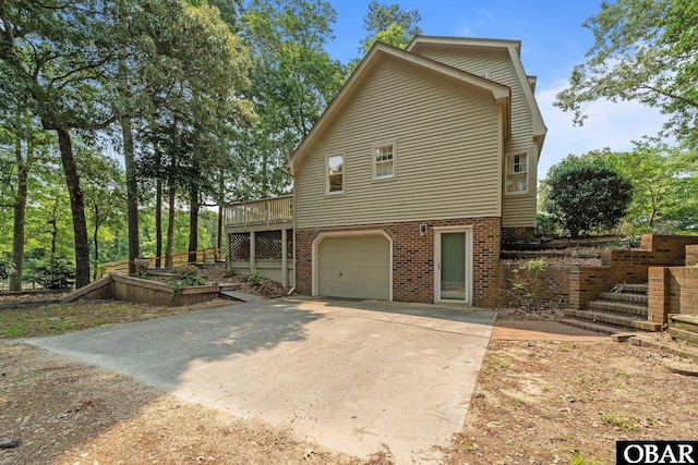 56 Ginguite Trl Lot 9, Southern Shores, NC 27949 - view of property exterior with an attached garage, brick siding, concrete driveway, a deck, and stairway