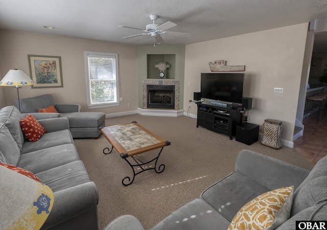 living room with carpet floors, a tile fireplace, baseboards, and ceiling fan