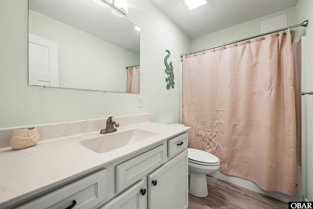 full bathroom featuring a shower with shower curtain, vanity, toilet, and wood finished floors